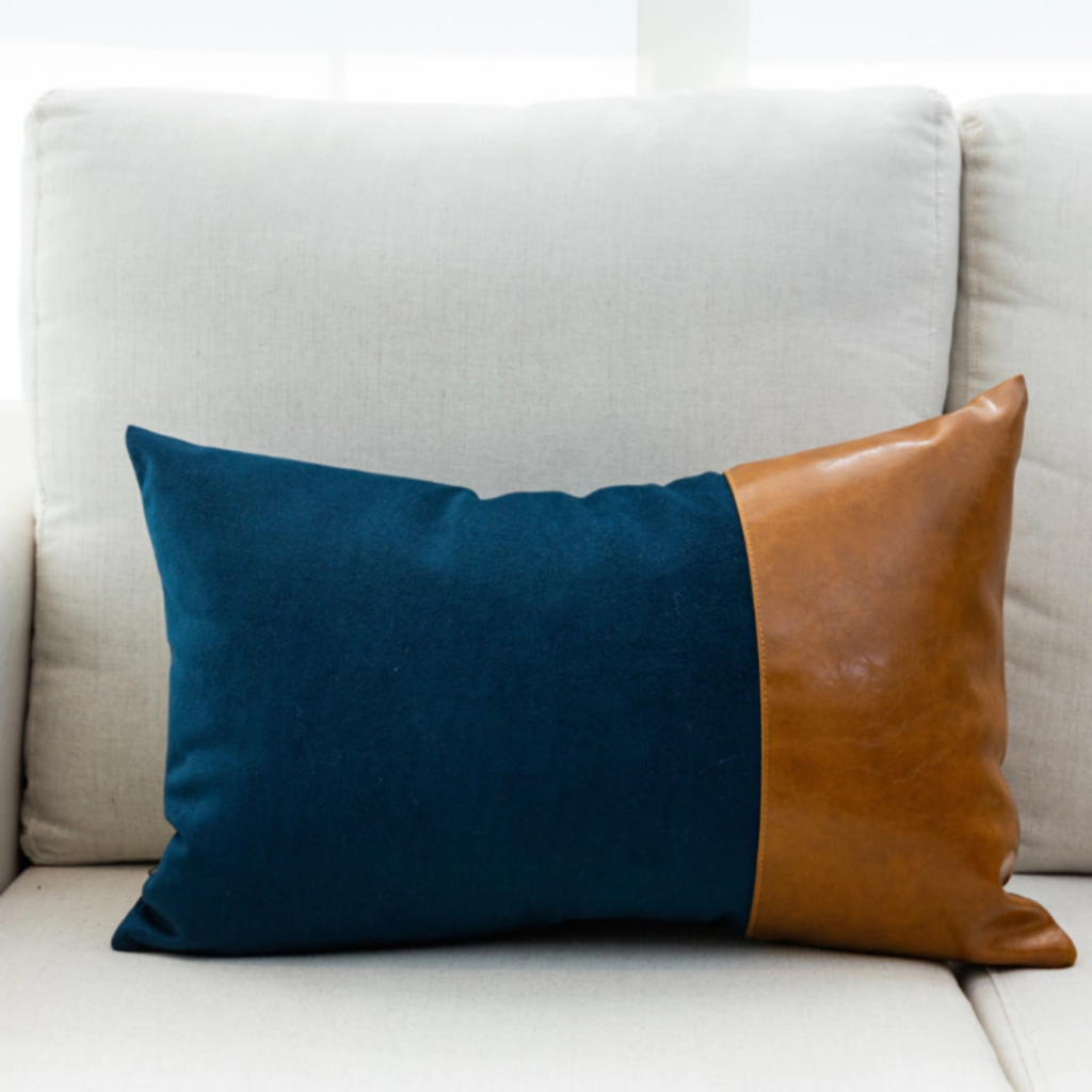 Almofada retangular em veludo e couro ecológico moderna e super versatil, esta peça é linda para dar um toque todo especial na sua poltrona ou sofá. Luxo e Sofisticação com estilo. Essa almofada maravilhosa tem shape retangular e é feita com veludo azul e couro ecólogico caramelo.