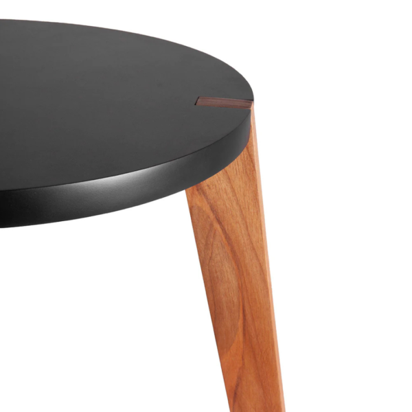 Mesa de apoio feita em madeira com tampo preto e três pés, na tonalidade natural da madeira, que são encaixados e deixados a mostra nos cantos do tampo. Móvel de design moderno, agrega um diferencial a decoração, pode ser usado em salas, escritórios e quartos. Criação desenvolvida por Andrés Fernandez e fabricado nacionalmente pela Modali Design.