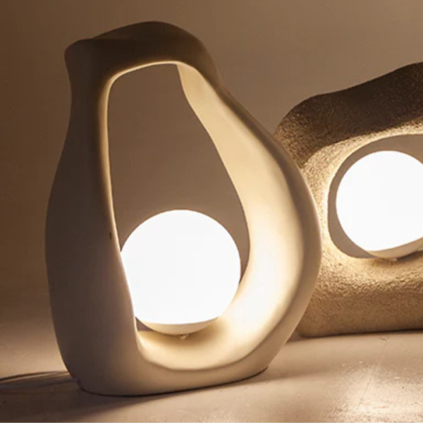 Luminária de mesa feito em resina com acabamento liso em tonalidade bege. Peça de design orgânico e elegante, agrega um diferencial a decoração. Bivolt. Desenvolvido e fabricado nacionalmente pela Modali Design.