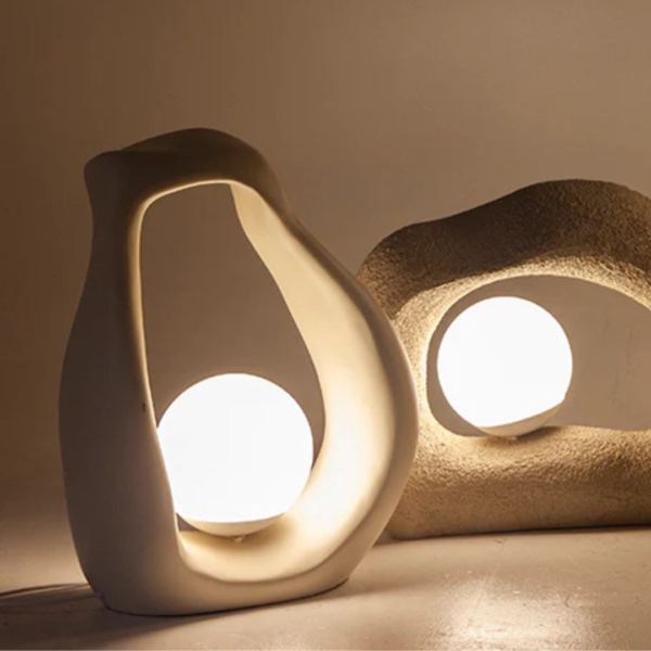 Luminária de mesa feito em resina com acabamento liso em tonalidade bege. Peça de design orgânico e elegante, agrega um diferencial a decoração. Bivolt. Desenvolvido e fabricado nacionalmente pela Modali Design.
