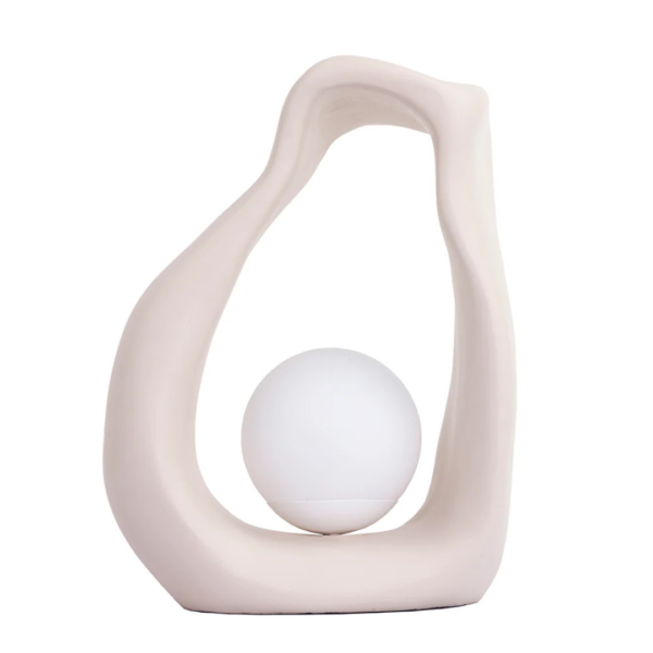 Luminária de mesa feito em resina com acabamento liso em tonalidade bege. Peça de design orgânico e elegante, agrega um diferencial a decoração. Bivolt. Desenvolvido e fabricado nacionalmente pela Modali Design.