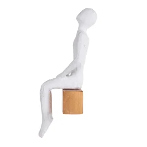 Escultura de resina na fisionomia de um homem sentando olhando para cima, sobre base também de resina com abertura para ser pendurada na parede. Adorno de acabamento rústico criado para ser exposto na parede com a escultura voltada para o lado esquerdo como se estivesse observando. Desenvolvido e fabricado nacionalmente pela Modali Design.