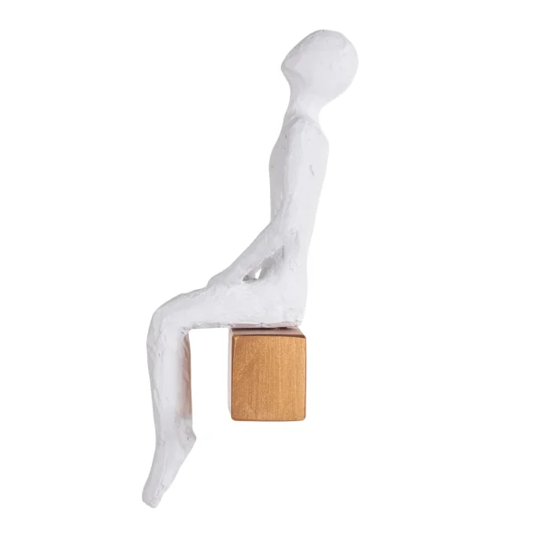 Escultura de resina na fisionomia de um homem sentando olhando para cima, sobre base também de resina com abertura para ser pendurada na parede. Adorno de acabamento rústico criado para ser exposto na parede com a escultura voltada para o lado esquerdo como se estivesse observando. Desenvolvido e fabricado nacionalmente pela Modali Design.