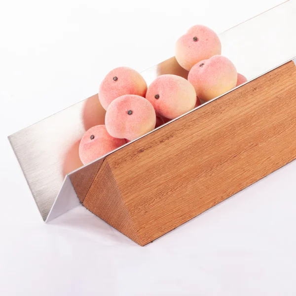Vértice é uma fruteira que se apropria de uma forma geométrica simples, o triângulo. Formada por 3 elementos apenas, a proposta é manter as frutas justapostas em linha reta. O rigor e formalidade estão presentes em uma peça de acabamento esmerado e complexidades de montagem. Detalhe para o trabalho de polimento e escovamento do aço e para a madeira de Sucupira, reconhecida por sua dureza e alta densidade.
