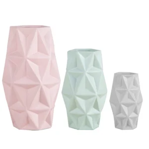 Jogo de três vasos em resina com design geométrico, possui três tamanho e colorações: grande na cor rosa, médio no verde e pequeno no cinza. Peça de design moderno com toque sutil, pode ser utilizado com o seu arranjo sobre mesas e estantes. Desenvolvido e fabricado nacionalmente pela Modali Design. Dimensões dos Vasos: Grande 28x16x16 cm Médio 21x13x13 cm Pequeno 15x10x10 cm