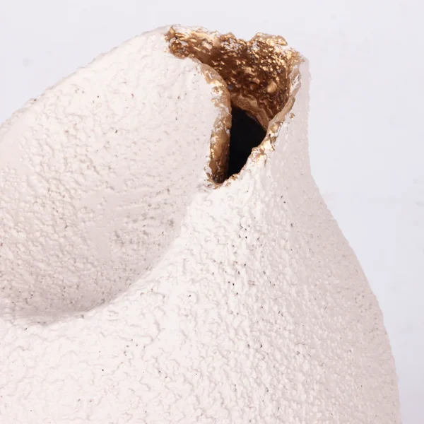 Vaso em resina com aspecto rustico em tonalidade areia, com design orgânico e acabamento interno em dourado. Peça de design moderno com toque sutil, pode ser utilizado com o seu arranjo sobre mesas e estantes. Desenvolvido e fabricado nacionalmente pela Modali Design.